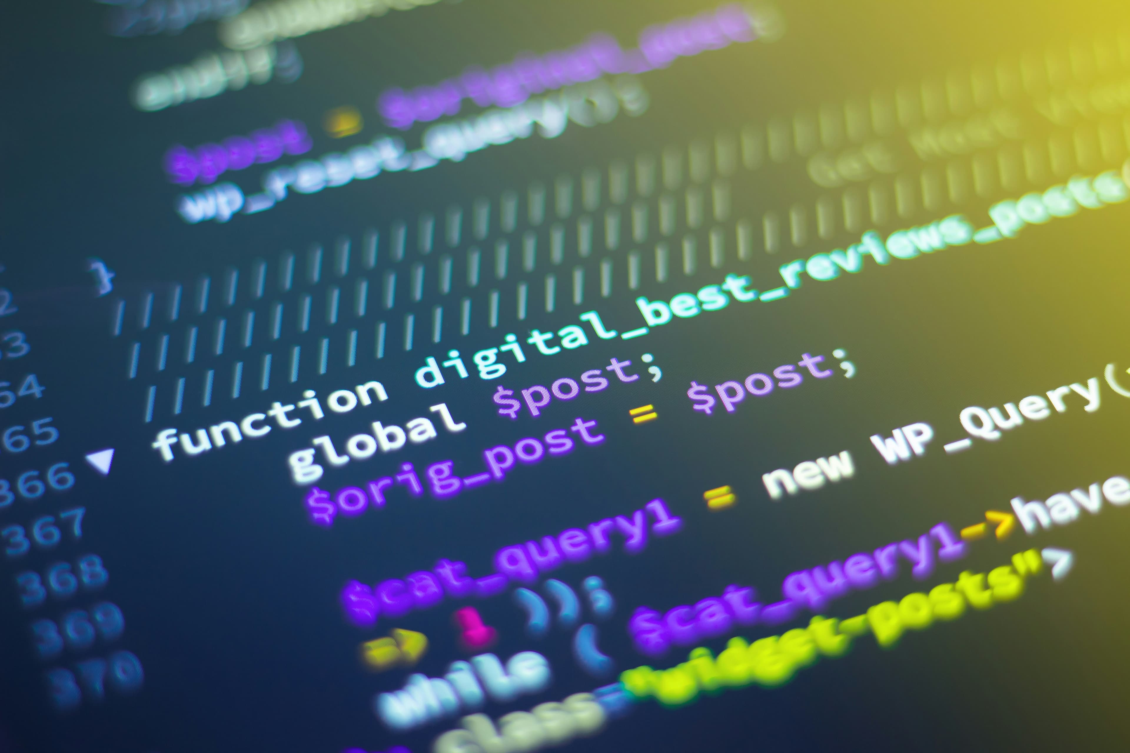 Close-up of code on a screen with blurred neon highlights.